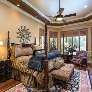 Master Bedroom with wood flooring, luxury bedding, area rug, bench, seating and lamp lighting